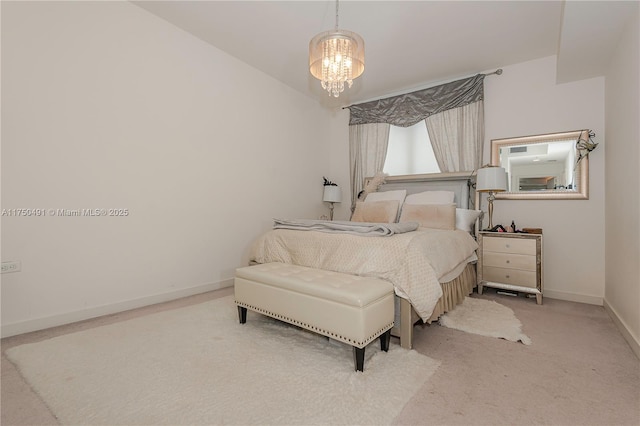carpeted bedroom featuring a notable chandelier and baseboards