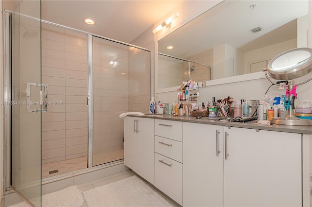 full bath featuring double vanity, visible vents, tile patterned flooring, a shower stall, and recessed lighting