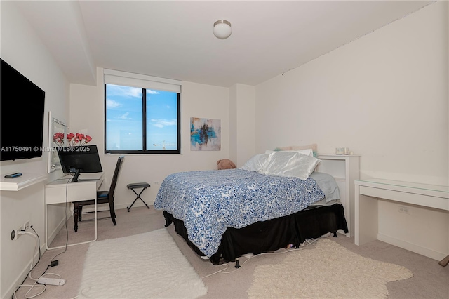bedroom featuring light carpet and baseboards