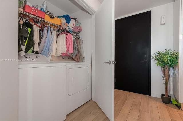 clothes washing area featuring light wood finished floors, laundry area, and separate washer and dryer