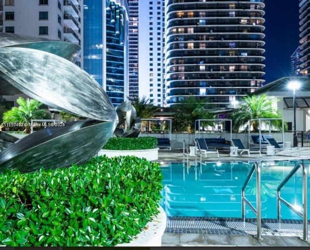 community pool with a view of city and fence