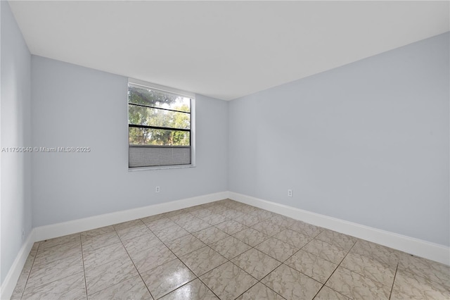 unfurnished room with baseboards