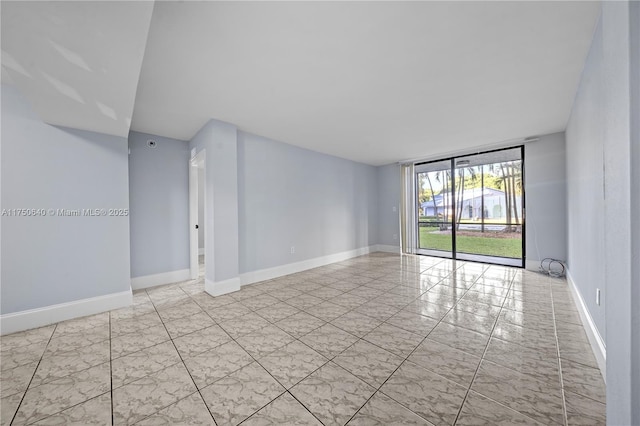 empty room featuring marble finish floor, floor to ceiling windows, and baseboards