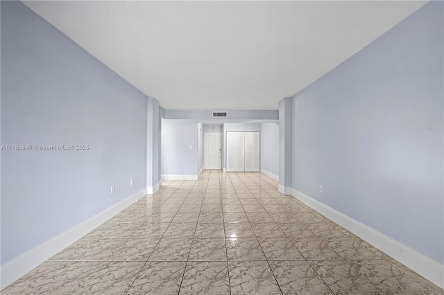unfurnished room with marble finish floor, visible vents, and baseboards