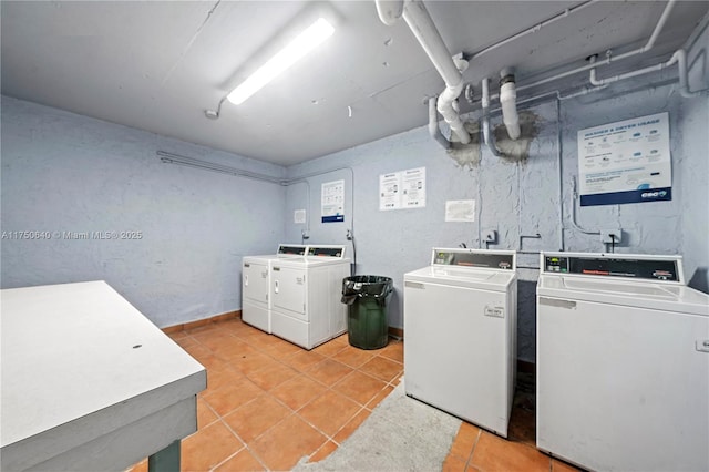 common laundry area featuring washer and clothes dryer and light tile patterned flooring