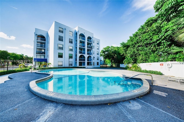 community pool featuring a patio area and fence