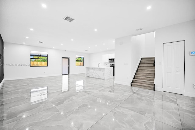 unfurnished living room featuring recessed lighting, marble finish floor, visible vents, and stairs