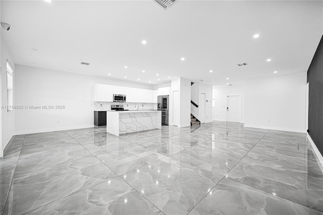 unfurnished living room featuring recessed lighting, marble finish floor, visible vents, and stairway