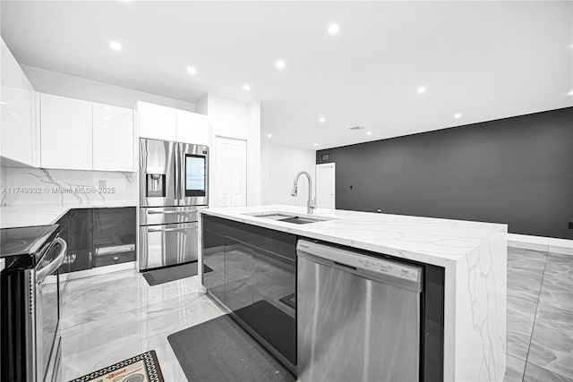 kitchen featuring a center island with sink, modern cabinets, stainless steel appliances, white cabinetry, and a sink