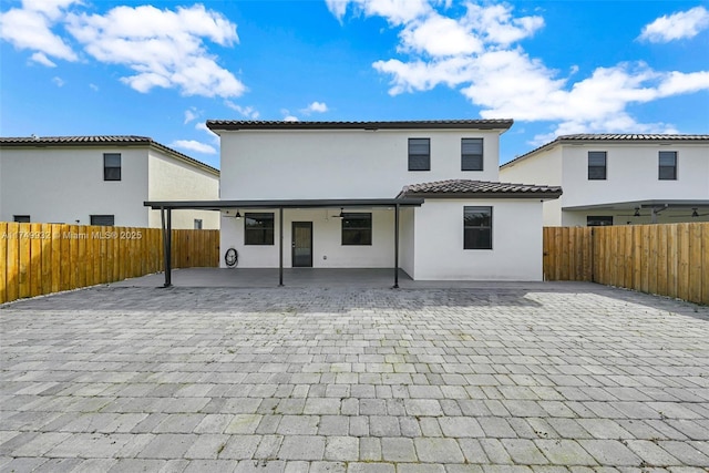 back of house with a patio area, a fenced backyard, and stucco siding