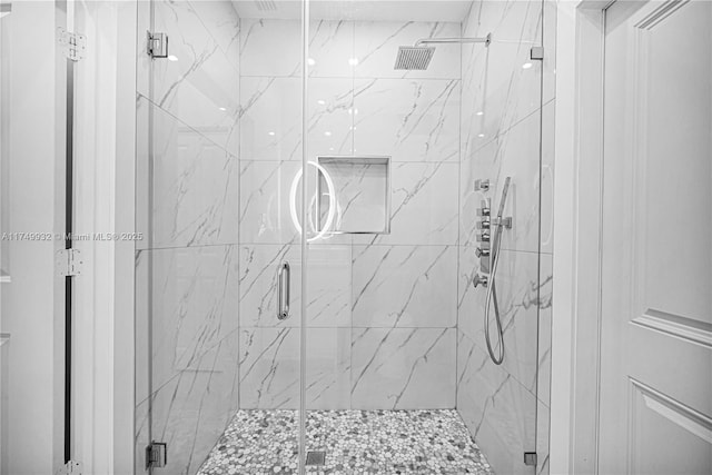 bathroom featuring a marble finish shower