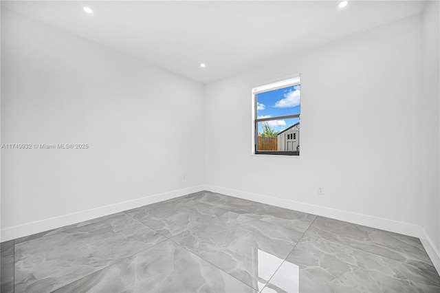 unfurnished room featuring recessed lighting and baseboards