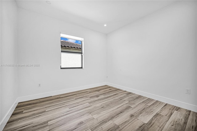 empty room with recessed lighting, light wood-style flooring, and baseboards