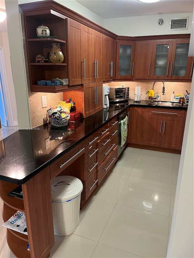 kitchen featuring a peninsula, visible vents, backsplash, open shelves, and glass insert cabinets