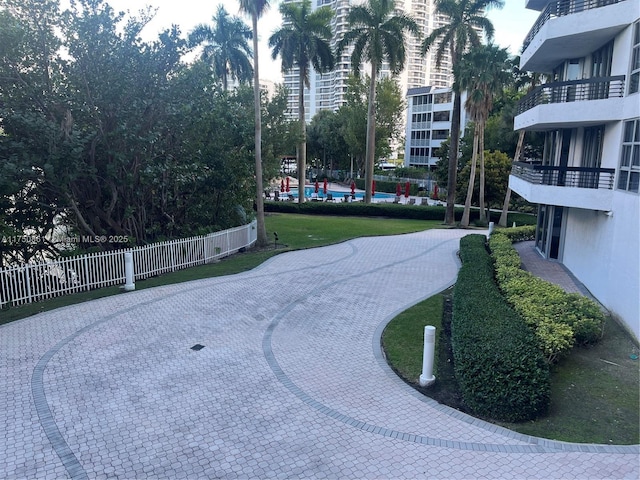 view of home's community with a yard and fence