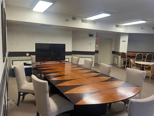 carpeted dining area featuring visible vents