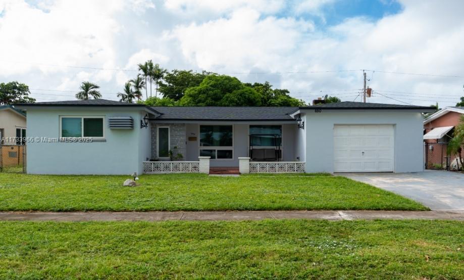 ranch-style house featuring a garage, concrete driveway, a front yard, and stucco siding