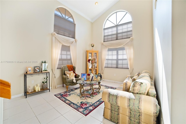 living area featuring baseboards, high vaulted ceiling, light tile patterned flooring, and crown molding