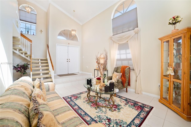 entrance foyer featuring crown molding, light tile patterned floors, stairway, high vaulted ceiling, and baseboards