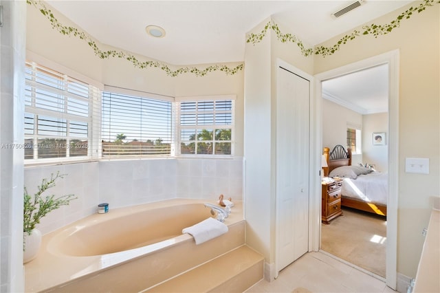 ensuite bathroom featuring a garden tub, plenty of natural light, ensuite bath, and visible vents