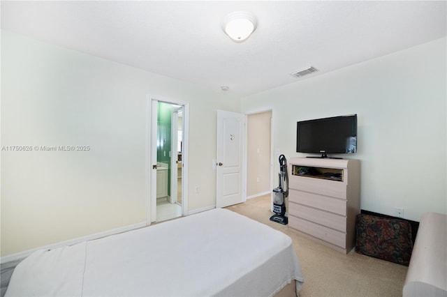 bedroom featuring light carpet, baseboards, visible vents, and ensuite bathroom