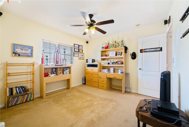 office area featuring baseboards, a ceiling fan, and light colored carpet