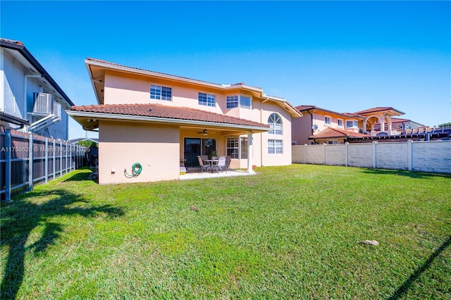 back of house featuring a patio area, a fenced backyard, a lawn, and stucco siding