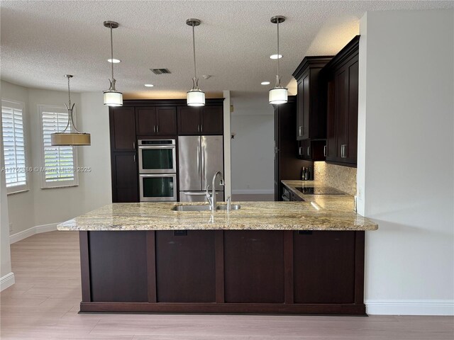 3962 Pinewood Ln, Weston, FL 33331 - kitchen with stainless steel appliances, a sink, a peninsula, baseboards, and dark brown cabinets