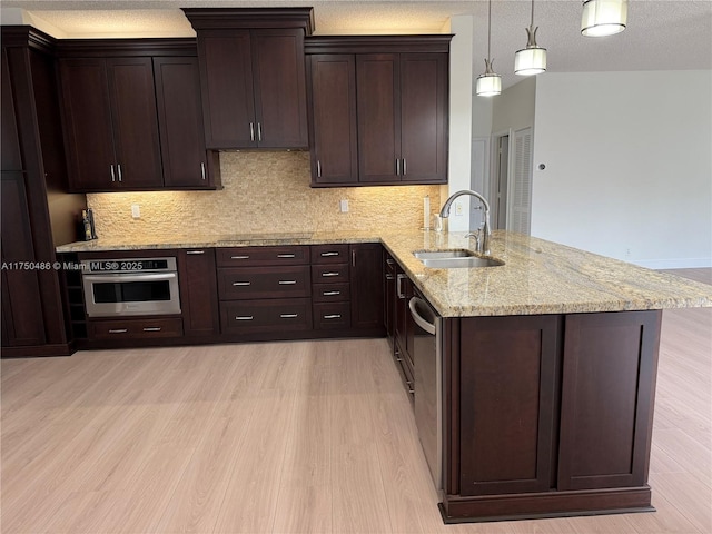 3962 Pinewood Ln, Weston, FL 33331 - kitchen featuring a sink, appliances with stainless steel finishes, light wood finished floors, a peninsula, and dark brown cabinetry