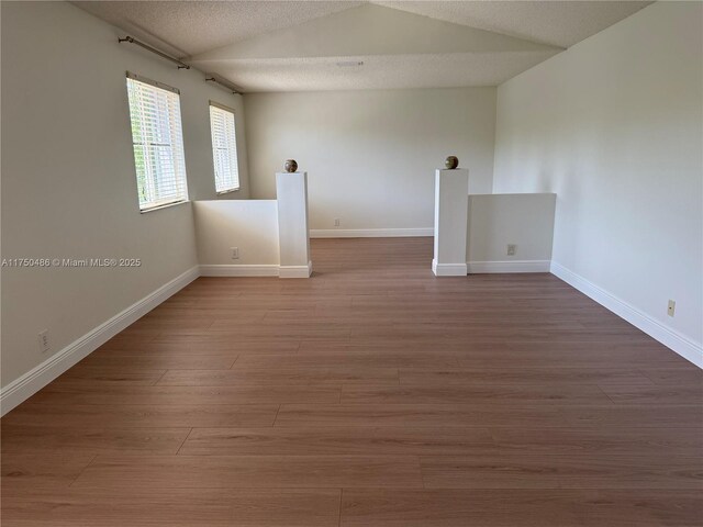 3962 Pinewood Ln, Weston, FL 33331 - spare room featuring lofted ceiling, baseboards, and wood finished floors