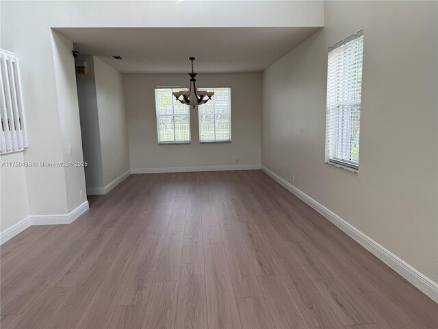 3962 Pinewood Ln, Weston, FL 33331 - spare room with a chandelier, light wood-style flooring, and baseboards