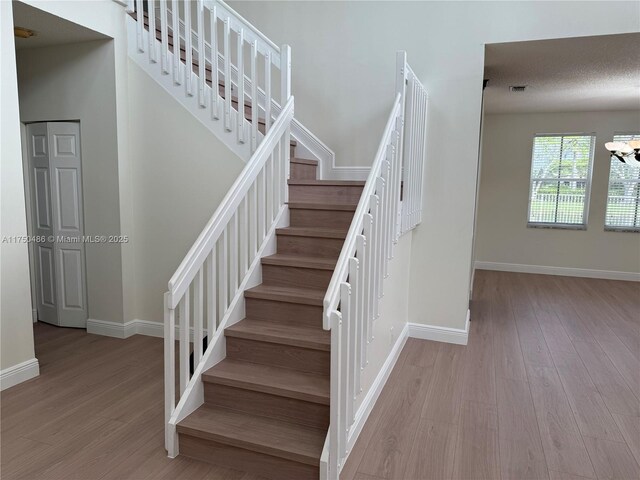 3962 Pinewood Ln, Weston, FL 33331 - stairs featuring wood finished floors, baseboards, and a chandelier