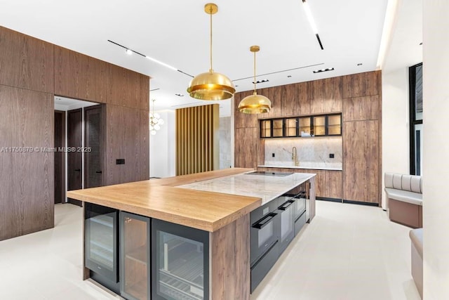 kitchen featuring tasteful backsplash, modern cabinets, a kitchen island, and pendant lighting