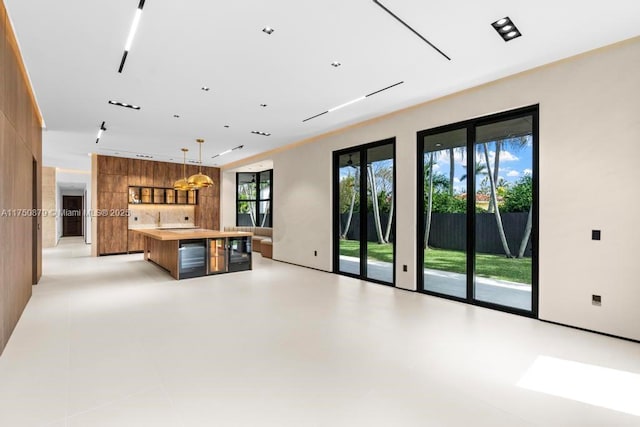 kitchen with light countertops, a center island, brown cabinetry, modern cabinets, and pendant lighting