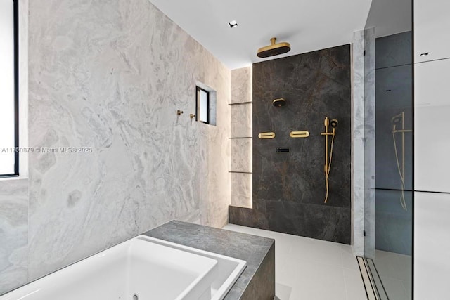 bathroom featuring tile patterned flooring, tile walls, a whirlpool tub, and walk in shower