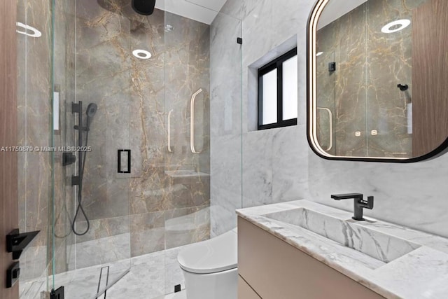 bathroom featuring toilet, a marble finish shower, tile walls, and vanity