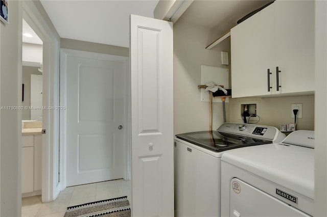 laundry area featuring light tile patterned floors, separate washer and dryer, and cabinet space