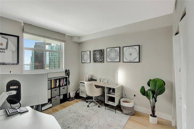 office area featuring light wood-type flooring and baseboards