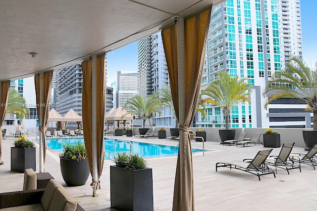 pool with a patio area and a city view