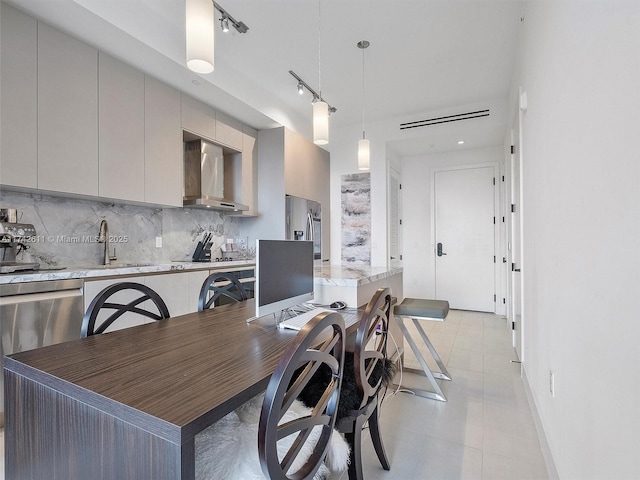 kitchen with tasteful backsplash, wall chimney exhaust hood, modern cabinets, gray cabinetry, and a sink