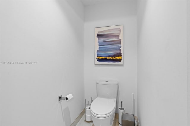 bathroom featuring baseboards and toilet