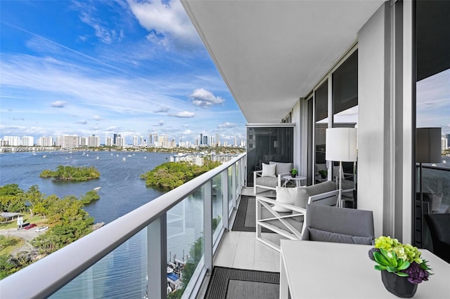 balcony featuring a water view and a city view