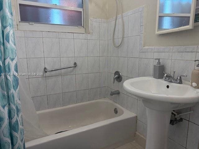 bathroom with shower / bath combination with curtain and tile walls