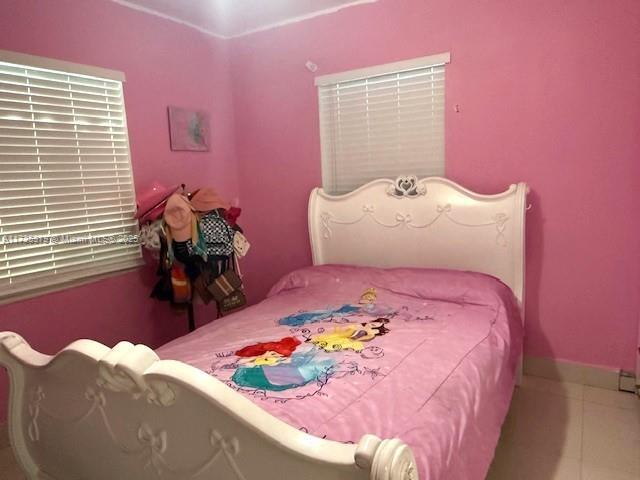 bedroom featuring tile patterned flooring and baseboards