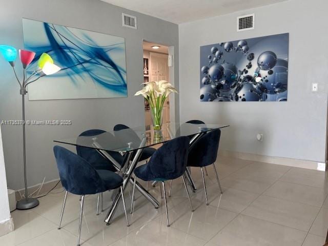 dining area featuring tile patterned flooring, visible vents, and baseboards