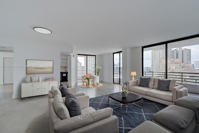 living room featuring a view of city, plenty of natural light, finished concrete floors, and baseboards