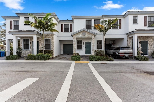 townhome / multi-family property with stone siding and stucco siding