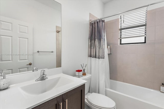 bathroom with shower / bathtub combination with curtain, vanity, and toilet