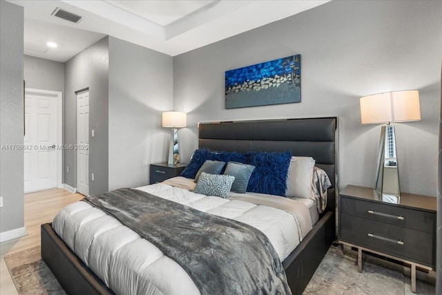 bedroom with baseboards, visible vents, wood finished floors, and recessed lighting