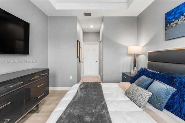 bedroom featuring light wood-type flooring, visible vents, and baseboards